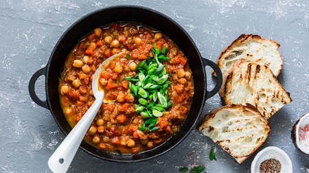 Black cooking pot full of chickpea and mushroom stew